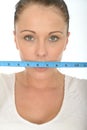 Healthy Young Woman Holding a Tape Measure Across Her Mouth Royalty Free Stock Photo