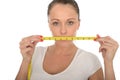 Healthy Young Woman Holding a Tape Measure Across Her Mouth Royalty Free Stock Photo