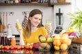 Healthy young woman in a kitchen with fruits and vegetables and juice Royalty Free Stock Photo