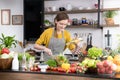 Healthy young woman in a kitchen preparing fruits and vegetables for healthy meal and salad Royalty Free Stock Photo