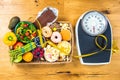 Healthy young woman looking at healthy and unhealthy food, trying to make the right choice Royalty Free Stock Photo