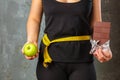 Healthy young woman looking at healthy and unhealthy food, trying to make the right choice Royalty Free Stock Photo