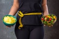 Healthy young woman looking at healthy and unhealthy food, trying to make the right choice Royalty Free Stock Photo