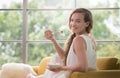 Woman lying on a couch holding a bowl of yogurt Royalty Free Stock Photo