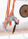 Healthy young women doing antigravity backward bending position in fly yoga hammock Royalty Free Stock Photo