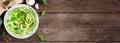 Healthy zucchini pasta topped with garlic and basil, above view side border on a rustic wood banner background Royalty Free Stock Photo