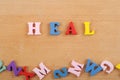 HEALword on wooden background composed from colorful abc alphabet block wooden letters, copy space for ad text. Learning english