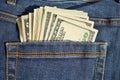 Heap of American money US currency, USD in the back pocket of blue jeans with yellow stitching as a symbol of black money Royalty Free Stock Photo