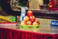 Heap of apples on a green plate inside a Buddhist temple for offering