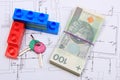 Heap of banknotes, keys and building blocks on drawing of house Royalty Free Stock Photo