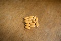 Heap of big multivitamin pills on wood
