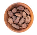 Heap of black cardamom pods in wooden bowl, isolated on white background. Black cardamon seeds. Clipping path. Top view. Royalty Free Stock Photo