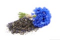Heap of black herbal tea blend with cornflower petals isolated on white background