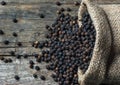 Heap of black pepper corns, peppercorns on wooden background Royalty Free Stock Photo