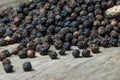 Heap of black pepper corns, peppercorns on wooden background Royalty Free Stock Photo