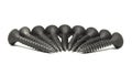 Heap of black steel screws arranged in a radial pattern