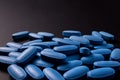 Heap of blue pills on a black background