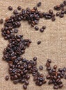 Heap of burnt coffee beans on sackcloth background