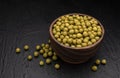 Heap of canned green peas on black background