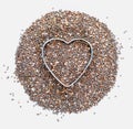 Heap of chia seeds with a heart. Love for chia. Isolated on white background. Macro close-up. With copy space Royalty Free Stock Photo