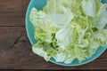 Heap of chopped lettuce In a blue plate on a wooden background Royalty Free Stock Photo