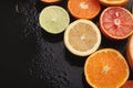 Heap of citruses and juice glass on black background Royalty Free Stock Photo