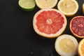 Heap of citruses and juice glass on black background Royalty Free Stock Photo