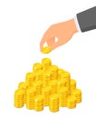 Heap of coins and a hand that puts a coin on top of it, savings concept Royalty Free Stock Photo