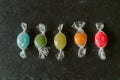 Heap of colorful fruity candies on black slate background. Close up view of different multicolored candies.