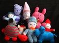 Heap of colorful kid`s soft stuffed handmade needle knitted toys / amigurumi against black