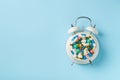 Heap of colorful pills and capsules and alarm clock. Time and healthcare concept Royalty Free Stock Photo