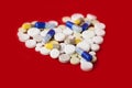 Heap of colorful pills in the shape of a heart, tablets and capsules onwhite background. Drug prescription for treatment