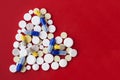 Heap of colorful pills in the shape of a heart, tablets and capsules onwhite background. Drug prescription for treatment Royalty Free Stock Photo