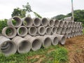 Heap of concrete drainage pipes stacked on construction site with diminishing perspective