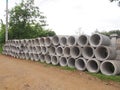 Heap of concrete drainage pipes stacked on construction site with diminishing perspective