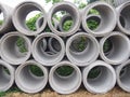 Heap of concrete drainage pipes stacked on construction site with diminishing perspective