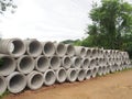 Heap of concrete drainage pipes stacked on construction site with diminishing perspective