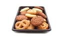 Heap of cookie on black plastic tray, on white