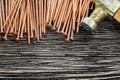 Heap of copper nails claw hammer on wooden board Royalty Free Stock Photo