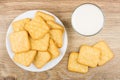 Heap of crackers in plate, glass of milk on table Royalty Free Stock Photo