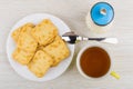 Heap of crackers in plate, sugar, teaspoon and tea