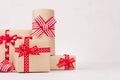 Heap different festive gift boxes with red ribbons and bows on white wood table with copy space, closeup.