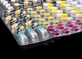 Heap of different sorts of medication and pills in packs on black background