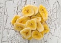 Heap of dried banana chips snack on white rustic table Royalty Free Stock Photo