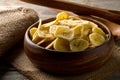 Heap of dried banana chips snack in wooden bowl on dark table Royalty Free Stock Photo