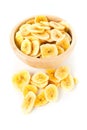 Heap of dried banana chips snack in wooden bowl over white Royalty Free Stock Photo