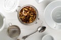 Heap of dried fruit tea infusion with oranges and strawberries mixed with tea leaves and assorted herbs in glass on white wooden Royalty Free Stock Photo