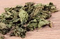 Heap of dried nettle on wooden surface