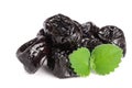 Heap of dried plums or prunes with a mint leaf on white background Royalty Free Stock Photo