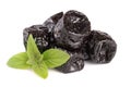 Heap of dried plums or prunes with a mint leaf on white background Royalty Free Stock Photo